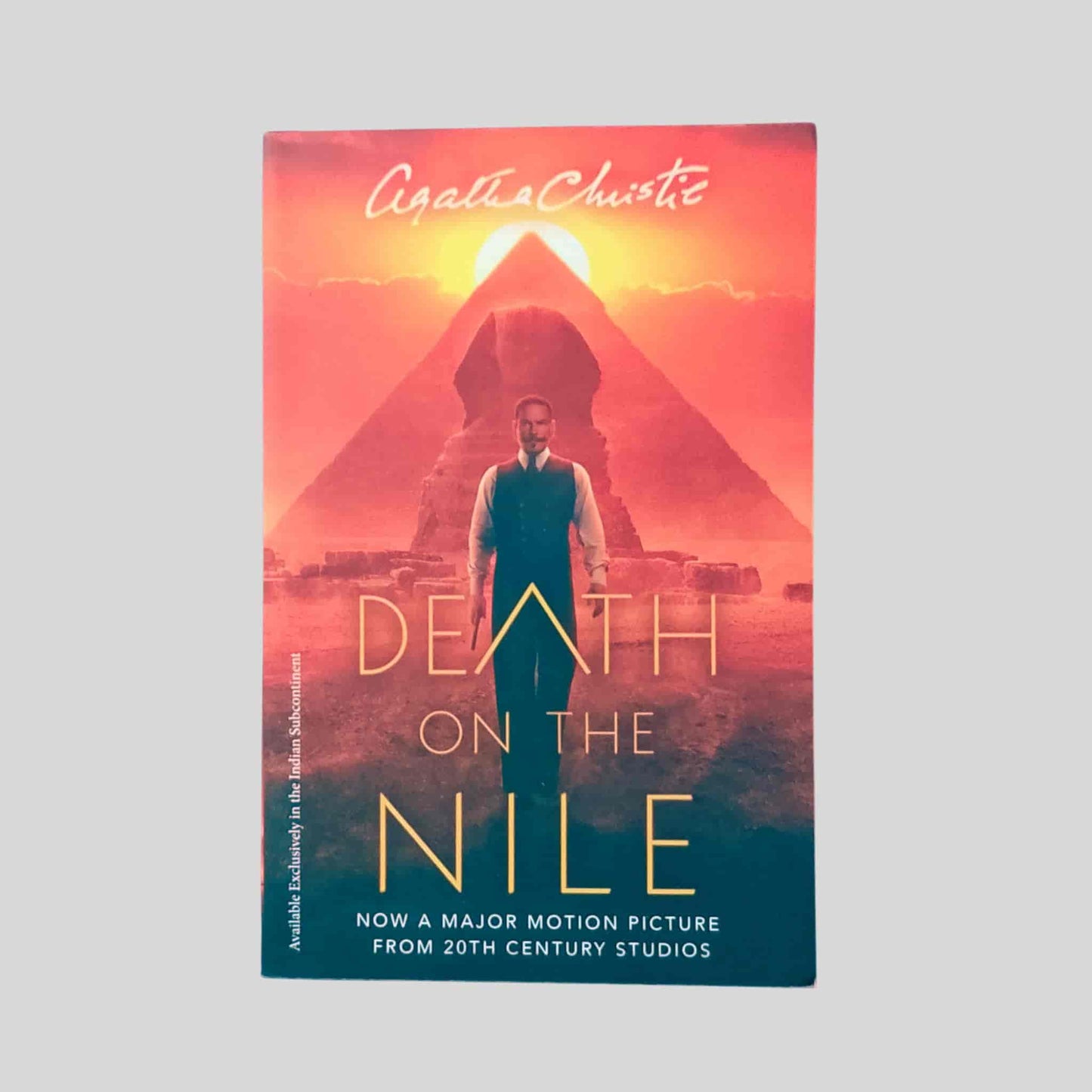 Book cover of Death on the Nile by Agatha Christie – features a man standing before the Great Sphinx and pyramid at sunset, promoting the 20th Century Studios major motion picture adaptation