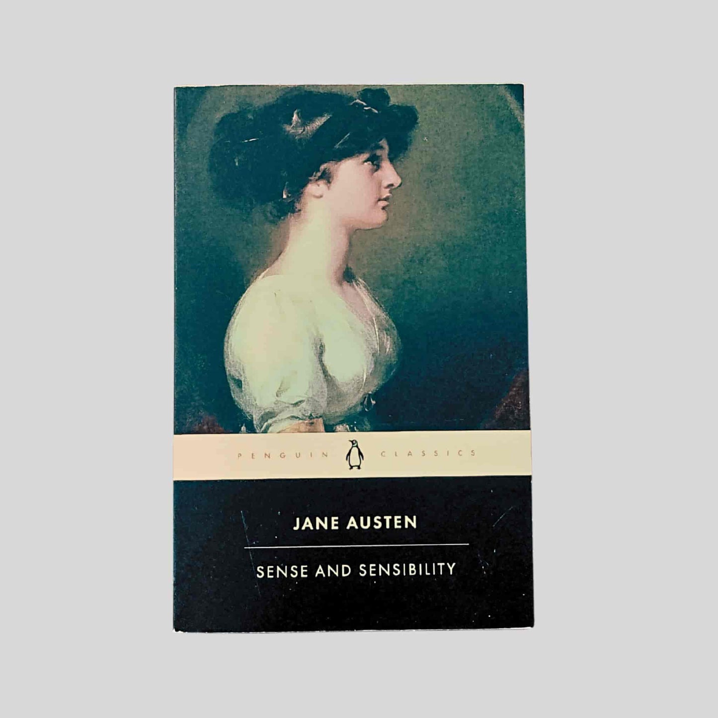 Paperback book cover of Sense and Sensibility by Jane Austen, Penguin Classics edition, featuring a side-profile Regency portrait of a young woman
