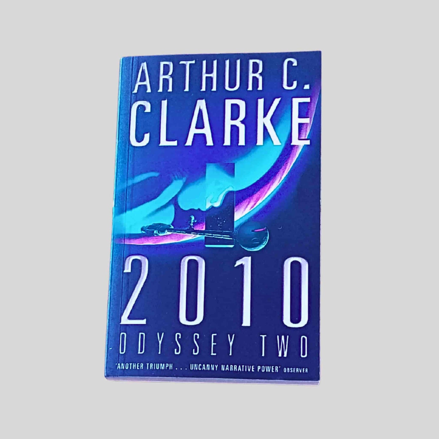 Book titled '2010 Odyssey Two' by Arthur C. Clarke on a grey background