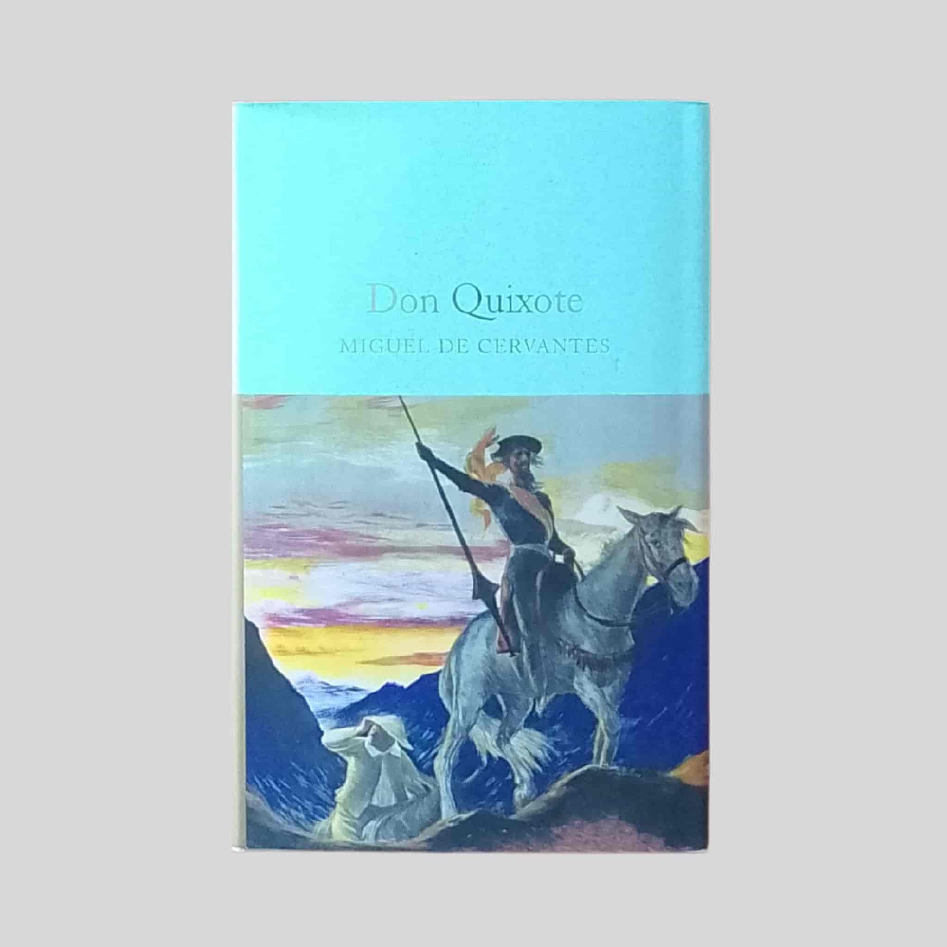Paperback cover of Don Quixote by Miguel de Cervantes, depicting an illustrated scene of Don Quixote on horseback with a lance against a mountainous landscape