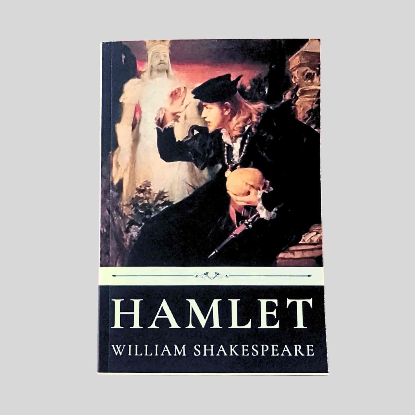 Paperback cover of Hamlet by William Shakespeare, depicting an illustrated scene of Hamlet holding a skull with the ghost of his father behind him