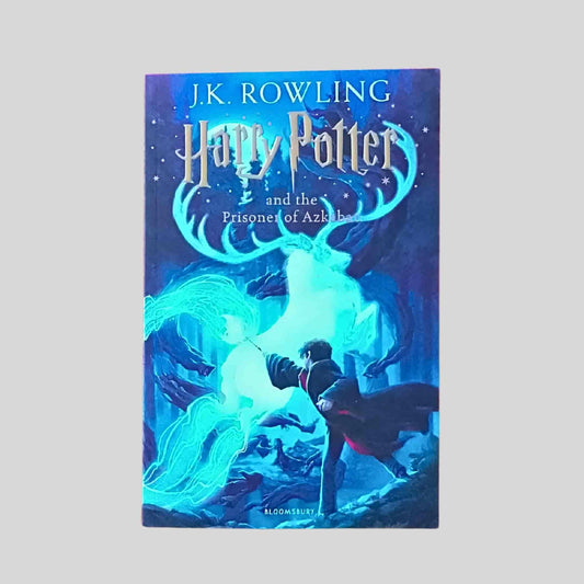 Front cover of Harry Potter and the Prisoner of Azkaban by J K Rowling showing Harry casting a spell and a glowing stag Patronus