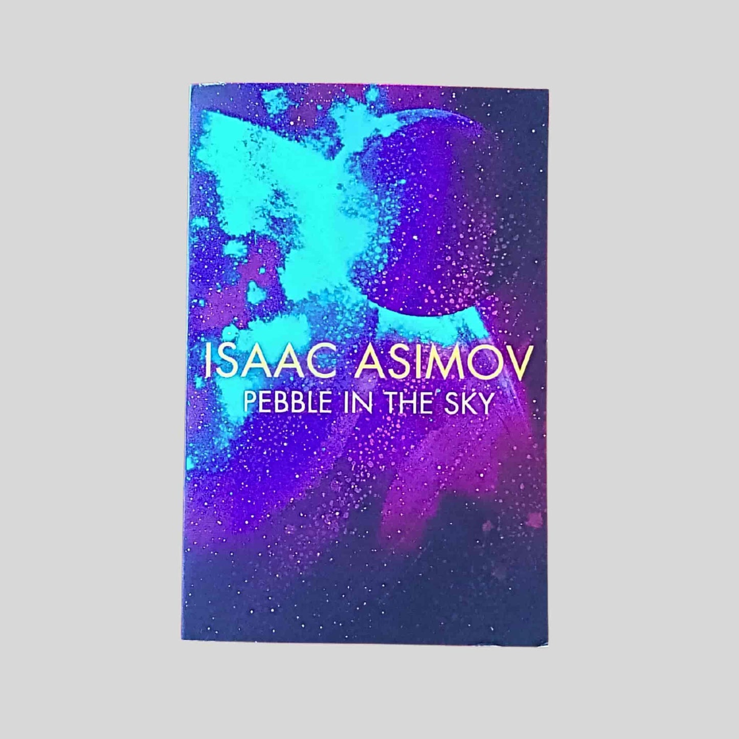 Book cover of 'Pebble in the Sky' by Isaac Asimov with a cosmic design