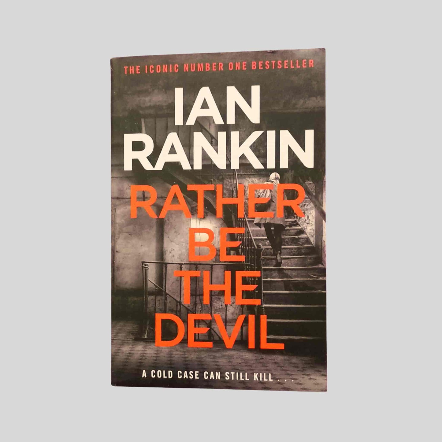 The crime thriller paperback book Rather Be the Devil by Ian Rankin featuring Inspector Rebus investigating a cold case in Edinburgh