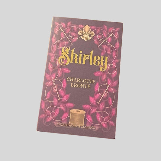 Book cover of 'Shirley' by Charlotte Bronte with decorative elements on a gray background