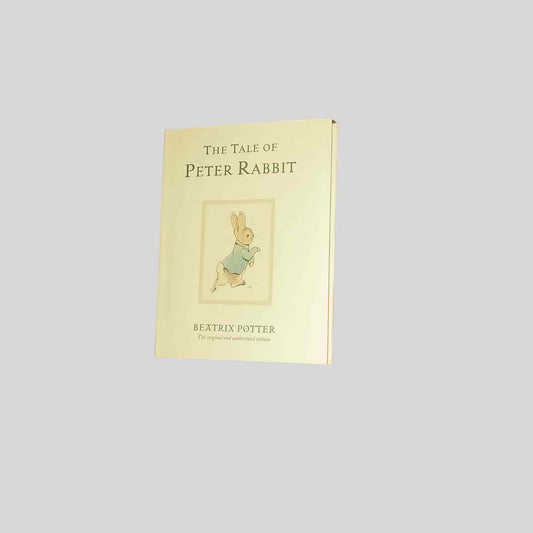 The front cover of the kids book The Tale of Peter Rabbit by Beatrix Potter – a cream cover featuring Peter in a blue jacket