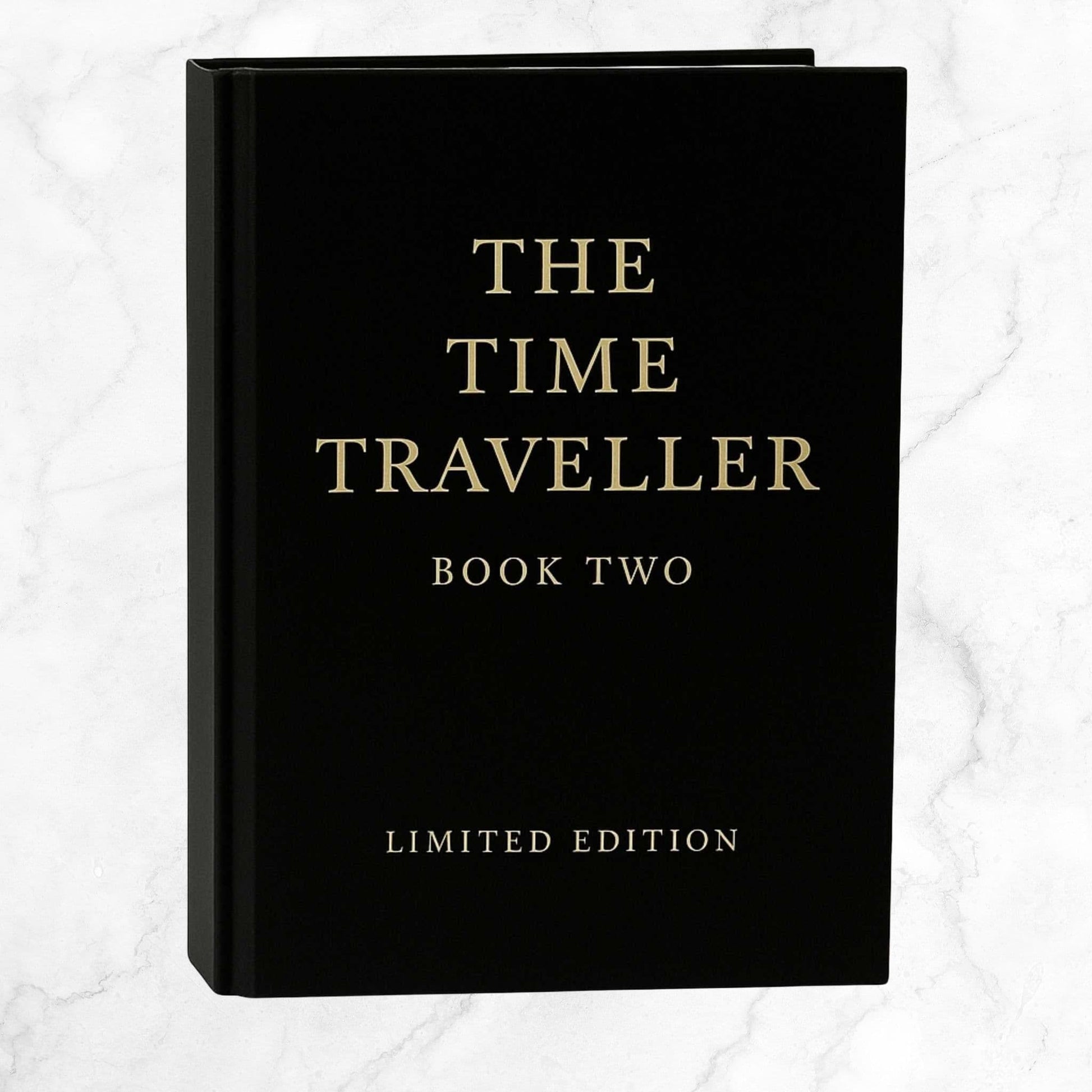 The Time Traveller Book Two limited edition hardcover, featuring gold serif lettering on a black cover, standing upright against a light background.