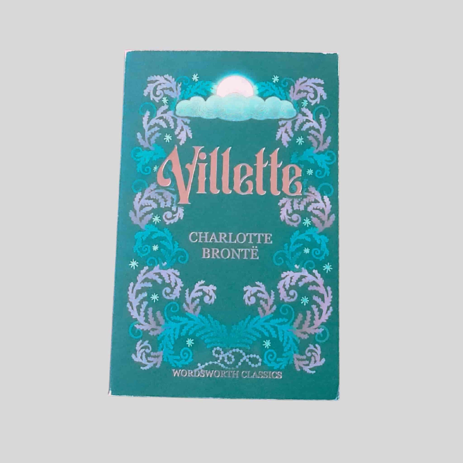 A decorative Wordsworth Classics edition of Villette by Charlotte Brontë, featuring gold lettering, an illustration of the moon behind a cloud at the top and swirling floral design down the sides