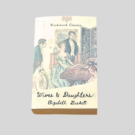 Paperback book cover of Wives and Daughters by Elizabeth Gaskell, Wordsworth Classics edition, featuring a Victorian family gathered around a piano in a nineteenth-century English drawing room