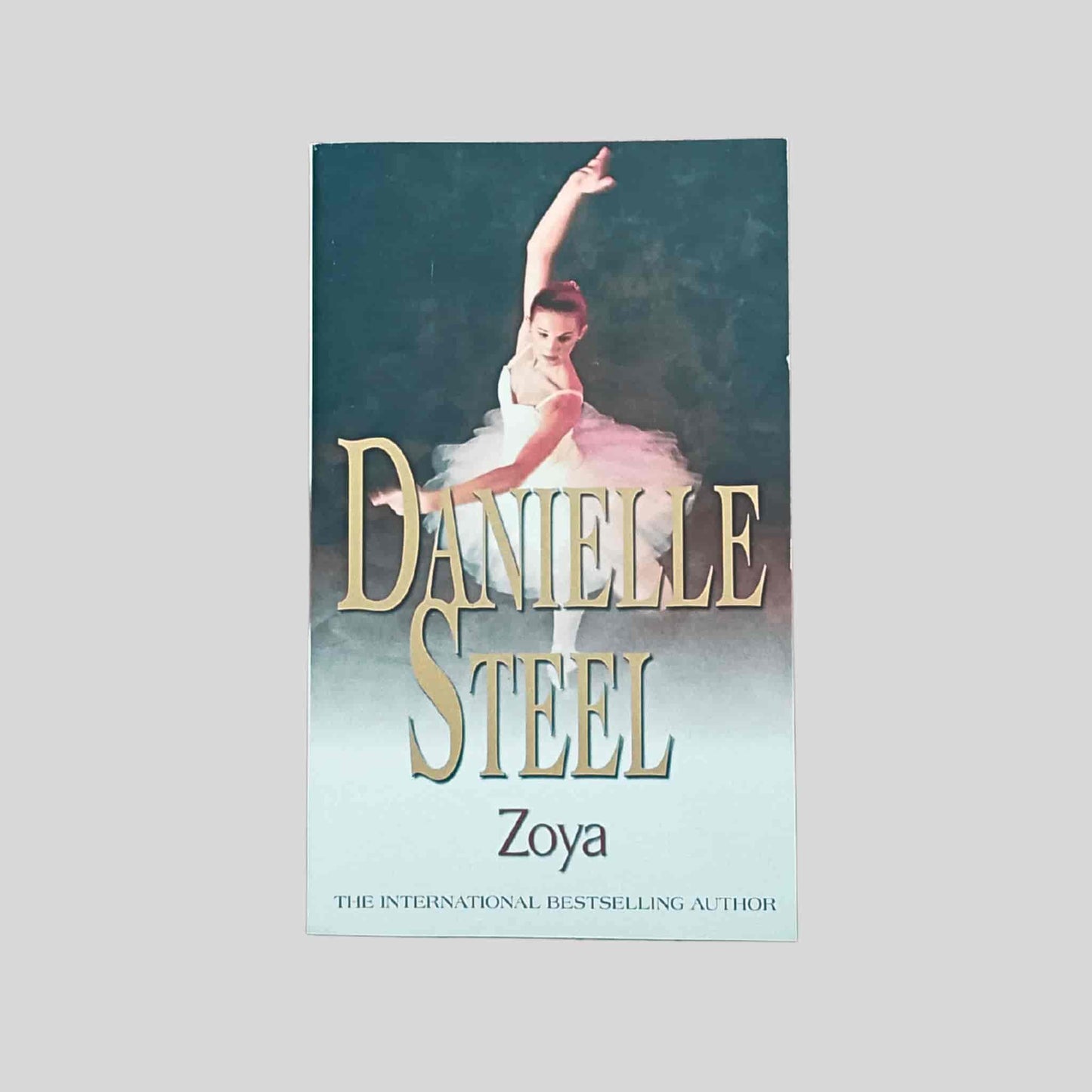 Paperback book cover of Zoya by Danielle Steel, featuring a ballet dancer in a white tutu posed gracefully against a dark stage background